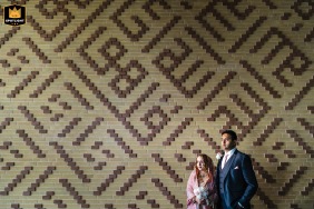 London, England, provides a stylish, urban setting for a couple's formal portrait as they stand together against a vibrant, geometrically patterned wall.